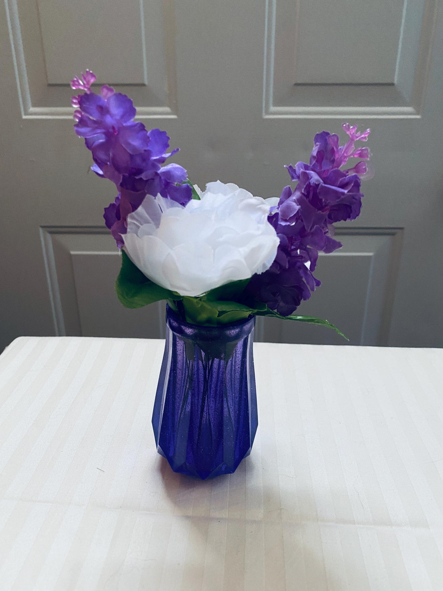 Set of two small hand-crafted purple resin vases.