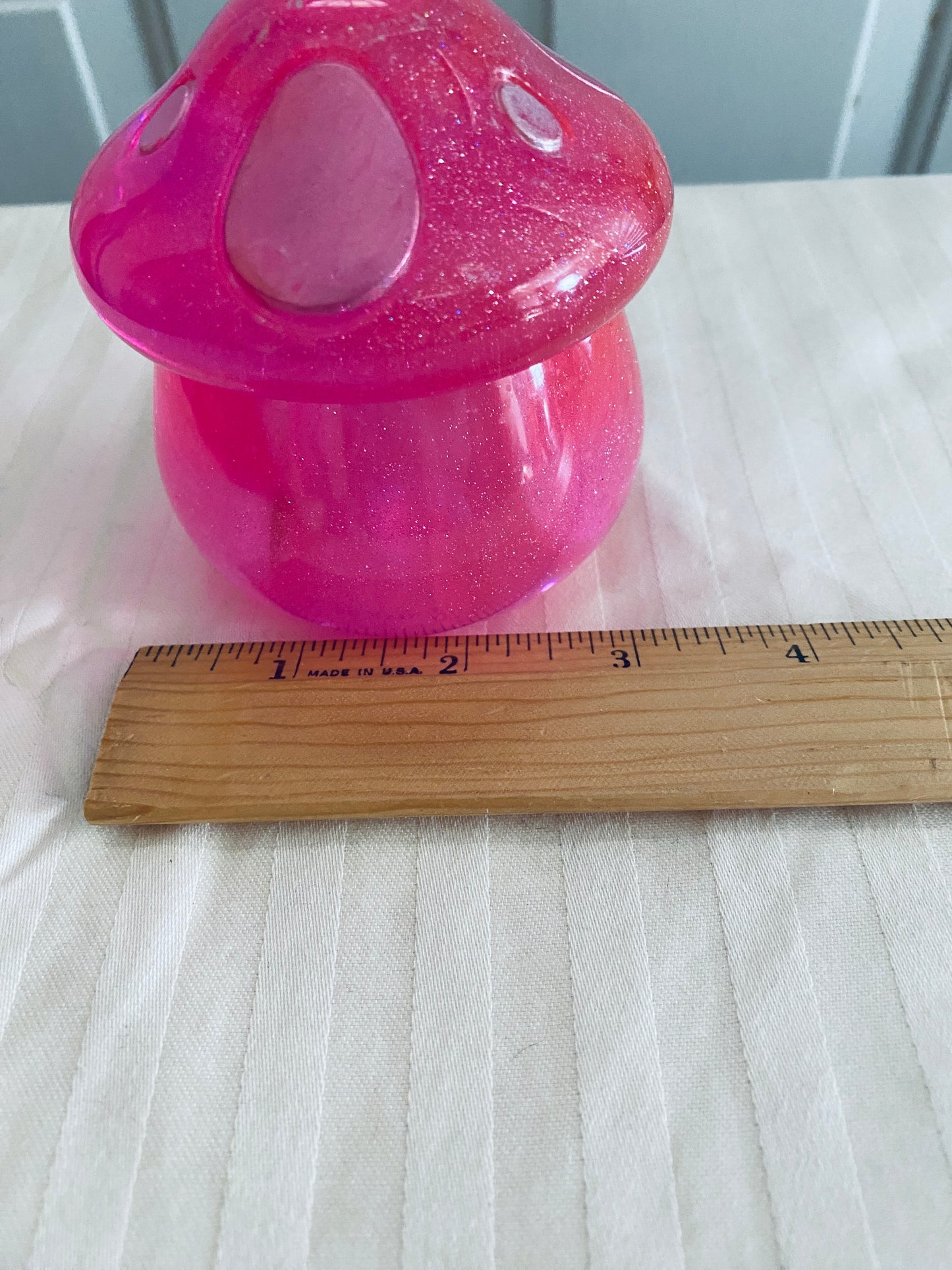 Pink mushroom-shaped pot with lid.