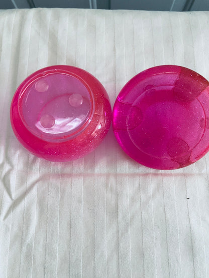 Pink mushroom-shaped pot with lid.