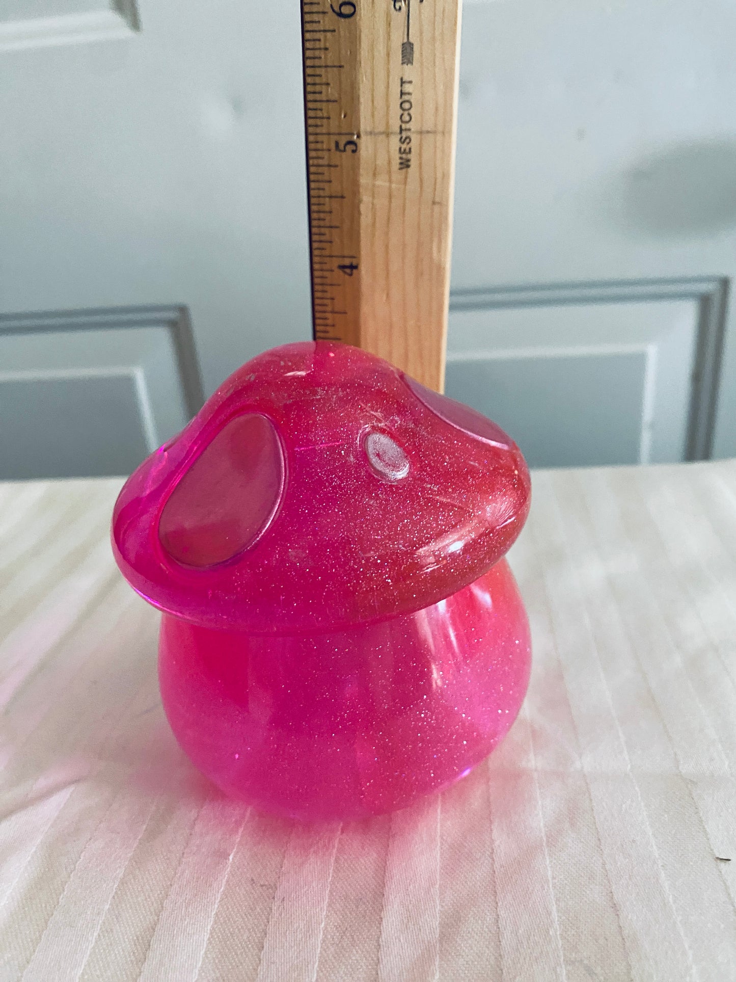 Pink mushroom-shaped pot with lid.