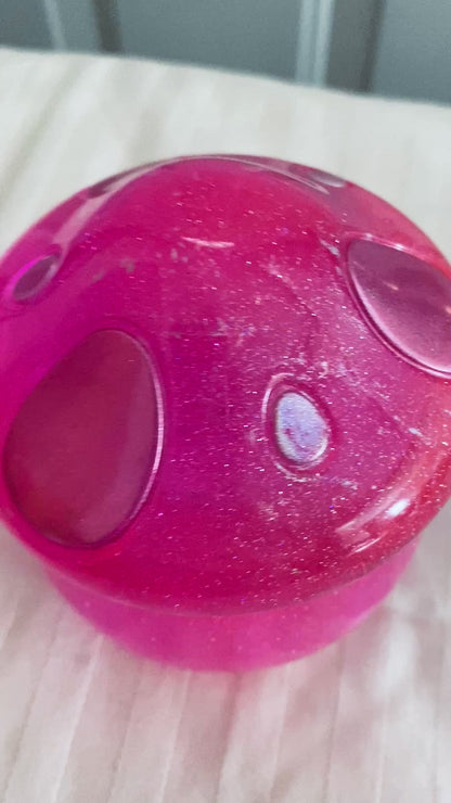 Pink mushroom-shaped pot with lid.